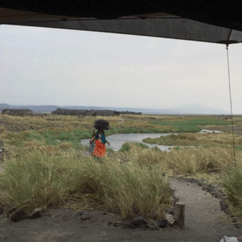 tanzaninaanse vrouw met bagage op haar hoofd lake Natrion tanzania