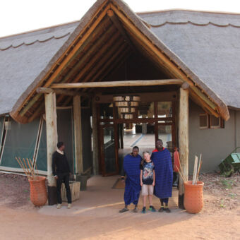 masai met zoon van familie voor de ingang van kubu kubu