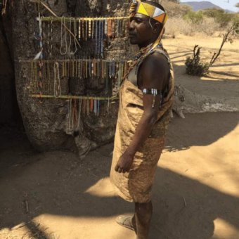 man met kralenketting op het hoofd die kettingen verkoopt tanzania