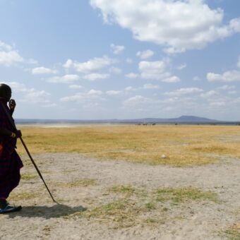 Masai man op de uitgestrekte vlaktes in de buurt van de Ngorongoro krater