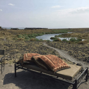 ligbed met kussens met uitzicht over het landschap van Natron Tanzania