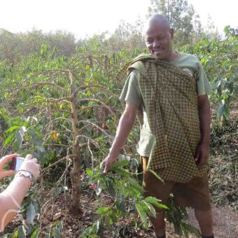 excursie bij een koffieplantage waarbij man uitleg geeft over de koffieplanten