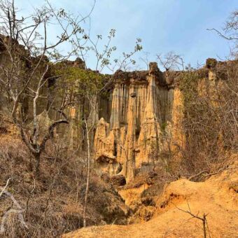 vanuit hoogte kijk je neer op een hoge pilarenwand in isimilia stone age