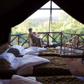 mand die op de veranda zit bij rhotia valley lodge in tanzania