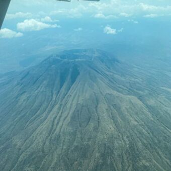 vanuit een vliegtuigje zie je de top van de Ol Doinyo Lengai vulkaan en kijk je in de krater. voor de masai is deze vulkaan heilig