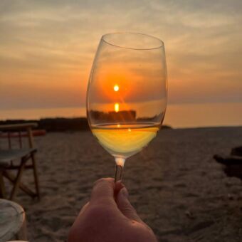 glas wijn waar de ondergaande zon doorheen schijnt