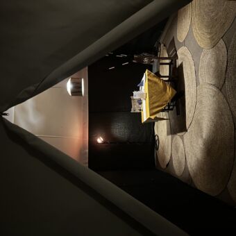 een tafel met twee stoelen in een safaritent die schemerig verlicht is voor een privédinner