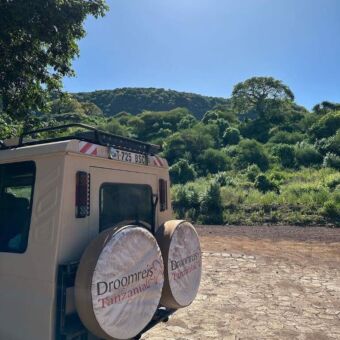 achterkant van een safari auto met op de banden een hoes van droomreis tanzania