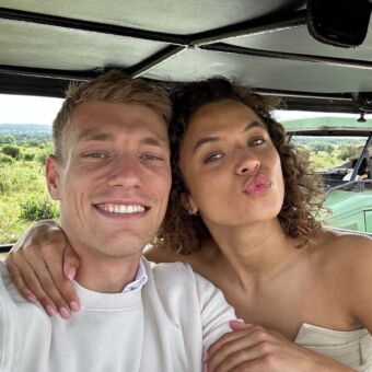 Tijdens een rondreis door Tanzania. Selfie van jonge man en vrouw staand in de safari auto Jonge man en vrouw tijdens een rondreis door Tanzania met Droomreis Tanzania Ze staan in de safari auto en maken een selfie. Allebei in het wit en lachend. De foto hoort bij een review over Droomreis Tanzania.