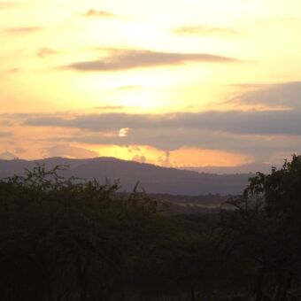 prachtige luchten met wolken en door de zonsondergang kleuren ze geel en oranje. op de achtergrond de bergen bij de serengeti
