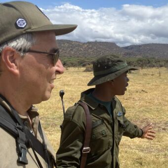 Vakantie Tanzania. OP een wandelsafari in Arusha national Park geeft een ranger uitleg aan een gast uit