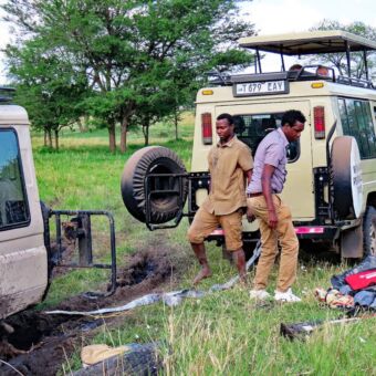 Safari auto van Droomreis Tanzania die vast zit op de Serengeti. Een tweede auto bied hulp en trekt de safariauto eruit. Reiservaring Tanzania