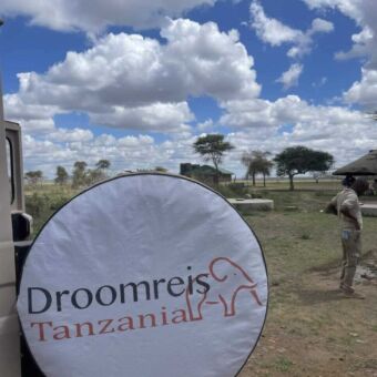 Reservewiel van de safariauto met een hoes er omheen waar Droomreis Tanzania op staat