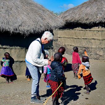 Vrouw omringt door kinderen tijdens een bezoek aan een Masai boma. Rondreis Tanzania review