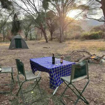 Genieten van deze speciale plek Kampeersafari Tanzania. Op een special campsite in Mkomazi een tafel met drankjes en een tentje op de achtergrond. verder niemand anders