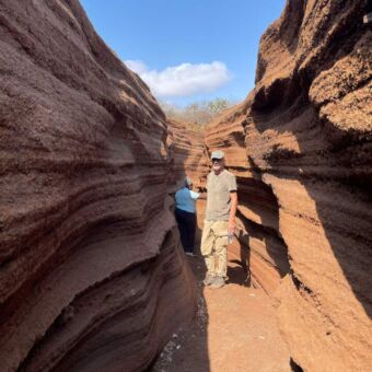 Wandeling bij Lake Chala door een uitgesleten rivierbedding 2 mensen in een uitgesleten terra-kleurige rivierbedding bij Lake Chala in Tanzania tijdens een wandeling van een inspectiereis van Droomreis Tanzania.