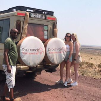 achter de safariauto de kok en twee reizigers van droomreis tanzania