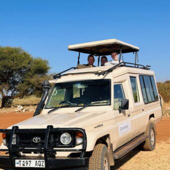reizigers staand in de safariauto van droomreis tanzania tijdens een gamedrive