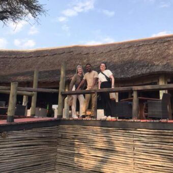 twee reizigers met hun gids op de veranda in ndutu bij een luxe lodge