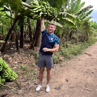 man tilt grote groene tros bananen