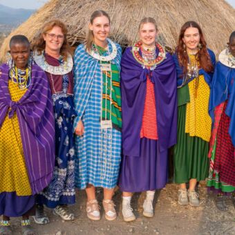 Reizigers in traditionele Masai kleding poseren samen met de Masai