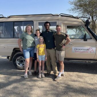 Reizigers met hun gids bij de safariauto