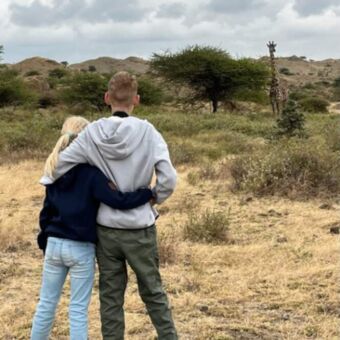 Reizigers kijkend naar een giraf tijdens een wandeling