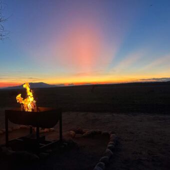 Kampvuur bij een ondergaande zon