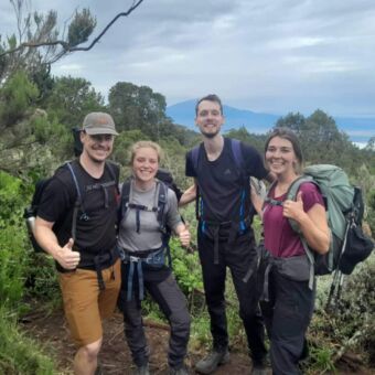 Lachende reizigers die de Kilimanjaro beklimmen