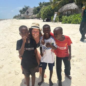 reiziger met lachende kinderen op het strand Zanzibar