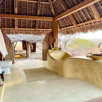 Luxe badkamer met bad, toilet. Helemaal open met allen een rieten dak erboven