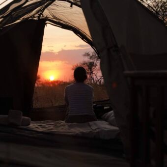Tent met een vrouw met zonsondergang