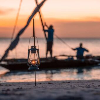 Visser op een traditionele boot bij zonsopkomst