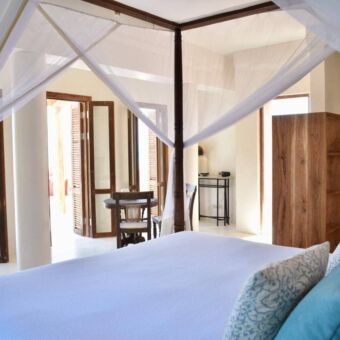 Slaapkamer met een mooi opgemaakt bed in een villa van Qambani