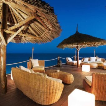 Terras met rieten parasols en banken en uitzicht over zee