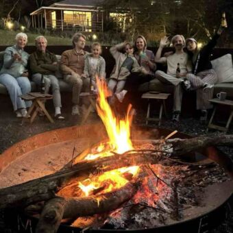 Rond een kampvuur zit een familie te borrelen