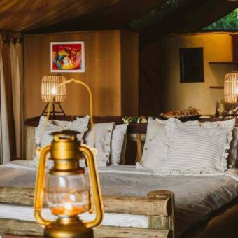Sfeervol ingerichte safari tent met mooi opgemaakt tweepersoons bed