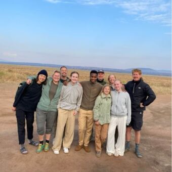 groepsfoto van grote familie met hun gids op de Serengeti
