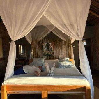 Mooi opgemaakt bed met klamboe in een lodge bij Ruaha