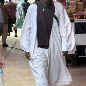 naar je toe lopende man gekleed in het wit met een tulband in Zanzibar