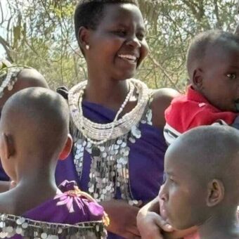 Lachende vrouw met allemaal kinderen om haar heen