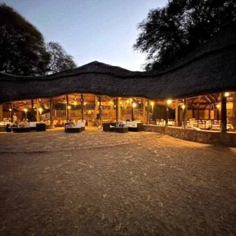 restaurant van een lodge met rietendak en mooi verlicht in Ruaha