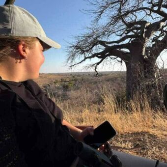 Vrouw in een open safari auto die dieren aan het spotten is Ruaha