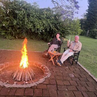 Twee mensen borrelen bij het kampvuur