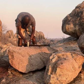 Een gids die koffie aan het maken is tijdens een wandelsafari