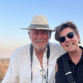 man en vrouw met verrekijker om de nek op safari