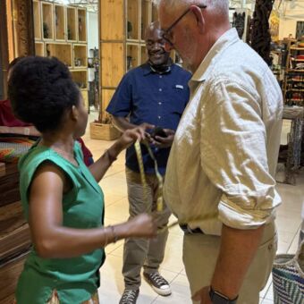 Vrouw die bij een man de maten opneemt voor een nieuwe blouse