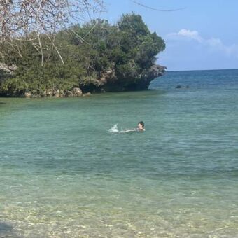 Vrouw die in de indische oceaan aan de kust van Tanzania zwemt